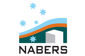 The image shows the NABERS logo, featuring stylized blue stars scattered above blue and orange wavy stripes, which cut across a green and white background with a white building outline. The word "NABERS" is written in black, capitalized letters at the bottom. It's all about enginuity.